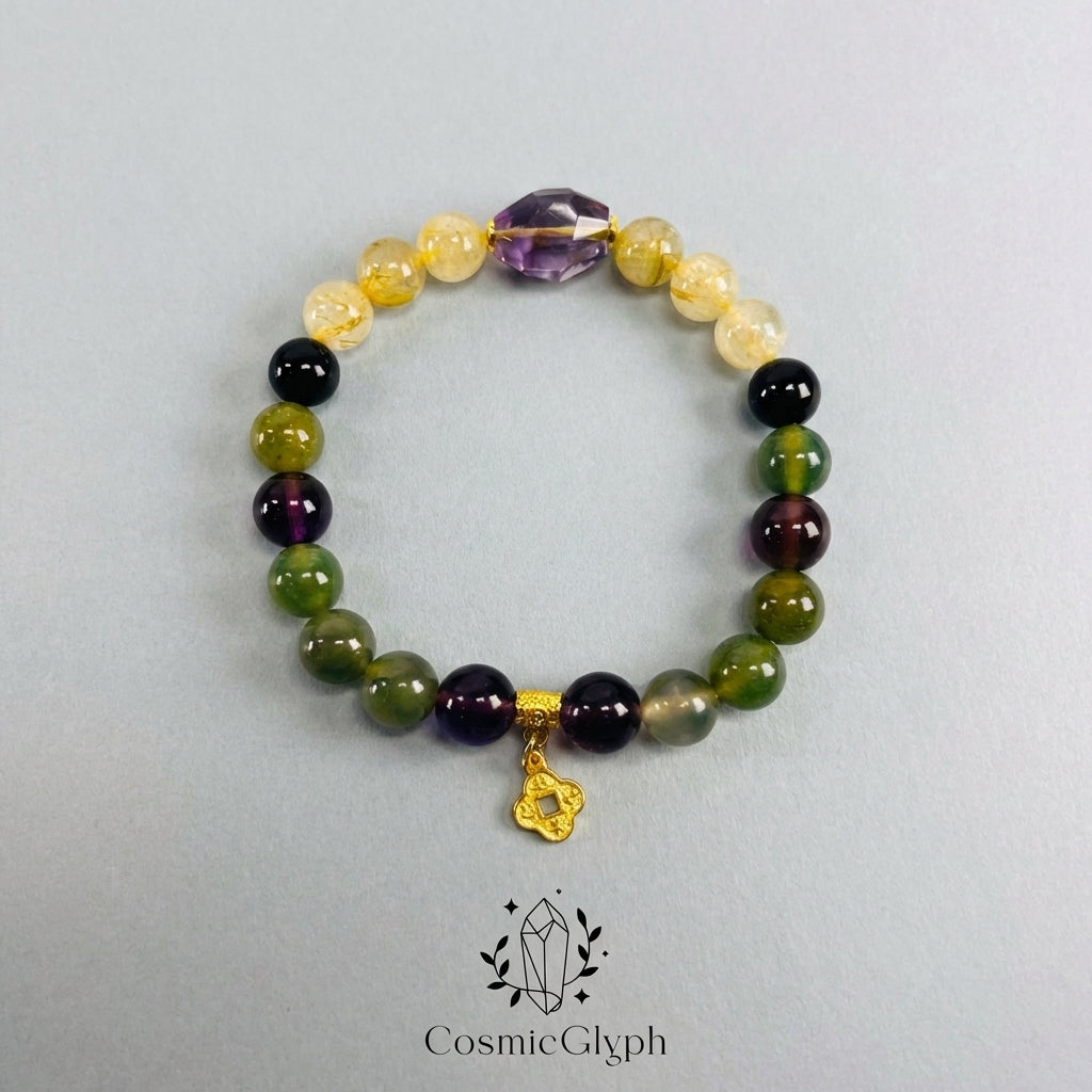 The CosmicGlyph Capricorn "Alchemist‘s Summit" crystal bracelet, featuring a mix of yellow, purple, green, and black beads with a large central Amethyst point and a delicate gold clover pendant, laid flat on a light grey background.