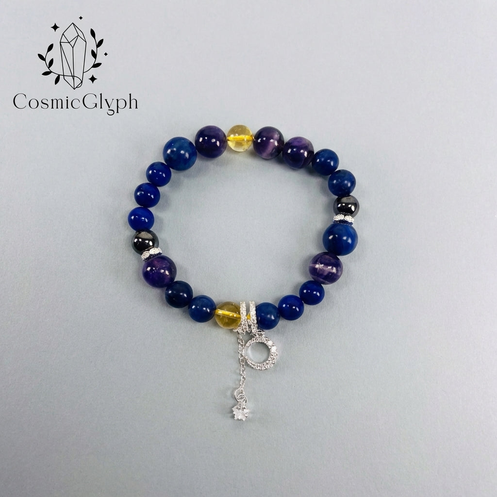 Product shot of the Sagittarius “The Astral Compass” crystal bracelet by CosmicGlyph, laid flat on a light grey background. Features a mix of dark blue, purple, yellow, and black beads with silver diamond-accented spacers and a delicate silver moon-and-star pendant. The CosmicGlyph logo with crystal motif is in the top left.