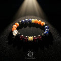 Dramatic close-up of the Leo “Sovereign‘s Roar” bracelet on black velvet under a stage spotlight. The bracelet features orange Sunstone, blue Lapis Lazuli, black Obsidian, and red Garnet beads with a prominent golden crown charm. The CosmicGlyph logo is visible at the bottom.