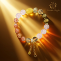 Product shot of the luxurious Leo crystal bracelet, featuring a rich array of colored beads and a central gold clasp with chains, set against a shimmering gold and brown gradient background.